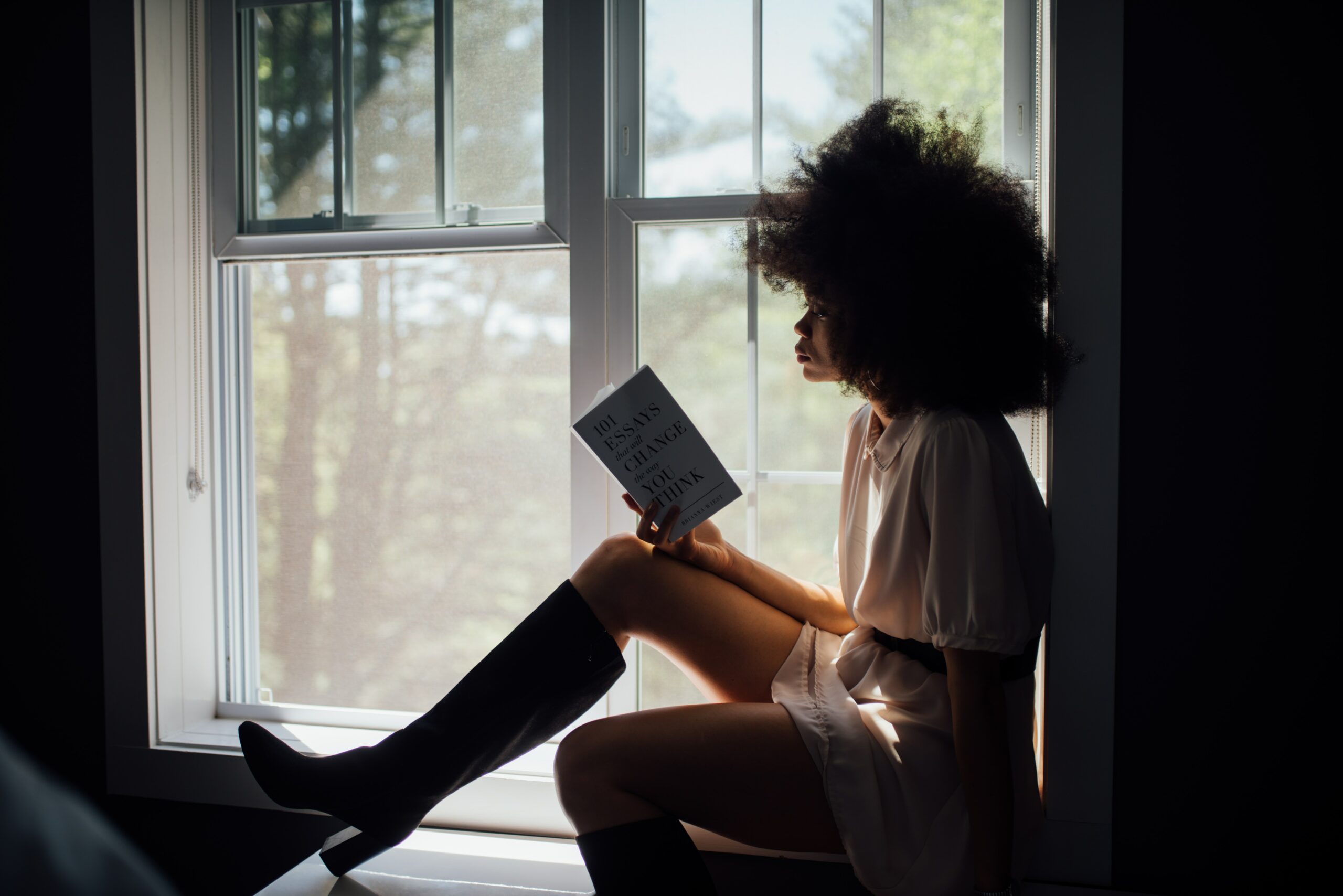 boekentips, vrouw leest in raam