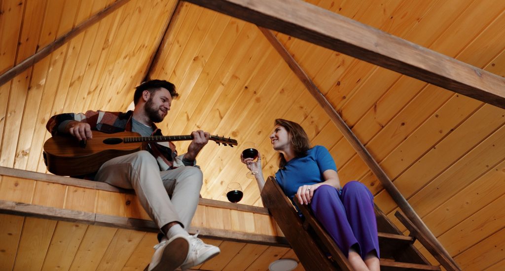duurzame mode voor mannen, man en vrouw met gitaar op zolder